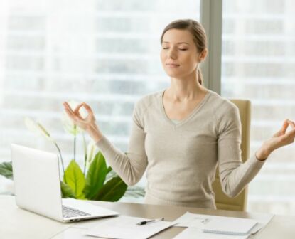 Image of a woman at work trying to relieve stress